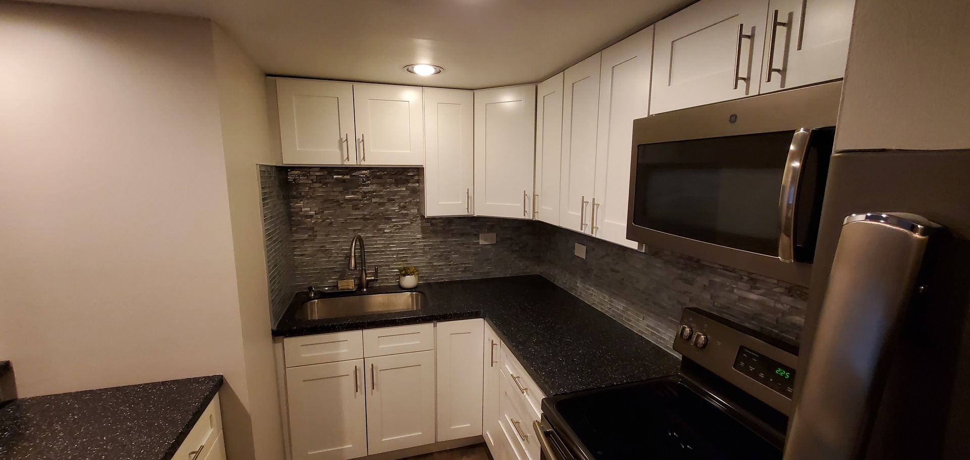 444 Spring Road, Unit 1 Elmhurst, IL 60126 - Photo 6 of 14 a kitchen with granite countertop white cabinets and black appliances