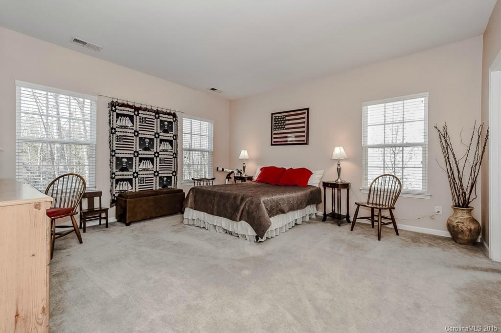 315 Calming Way Tega Cay, SC 29708 - Photo 12 of 24 a spacious bedroom with a bed a table chair and a window