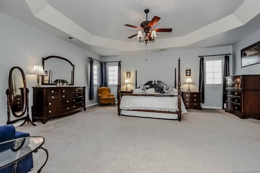 315 Calming Way Tega Cay, SC 29708 - Photo 15 of 24 a spacious bedroom with a bed a couch and a chandelier