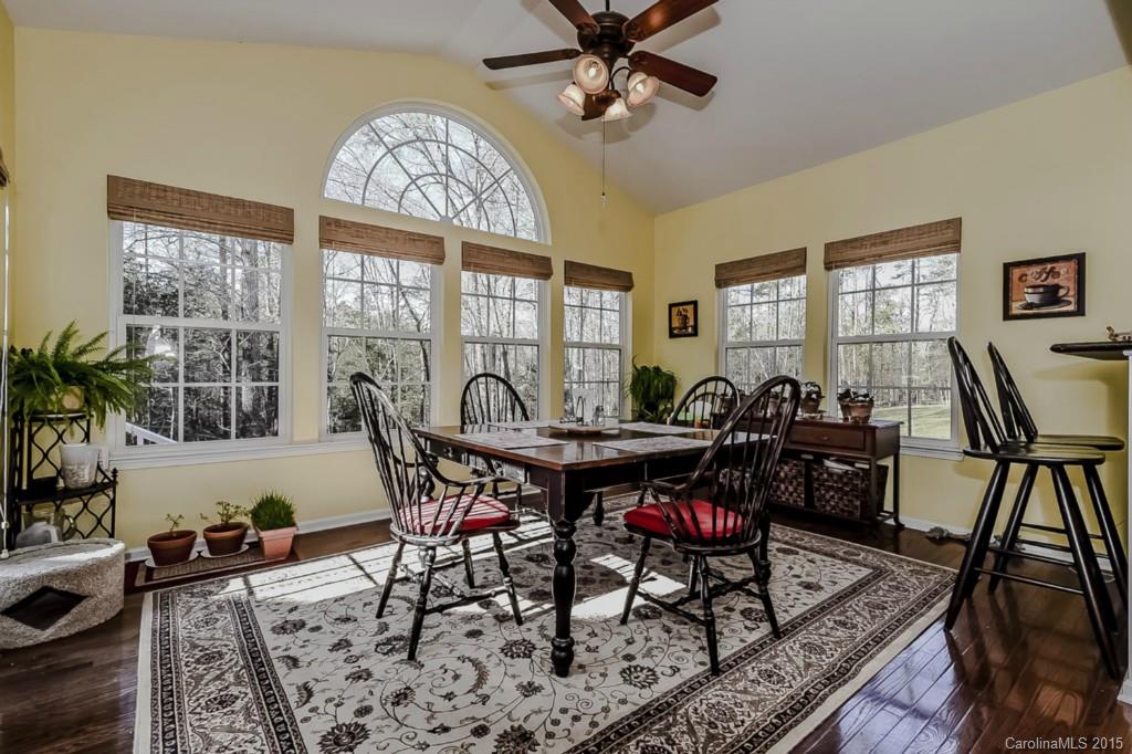 315 Calming Way Tega Cay, SC 29708 - Photo 9 of 24 a view of a dining room and livingroom with furniture wooden floor a rug a painting and a chandelier