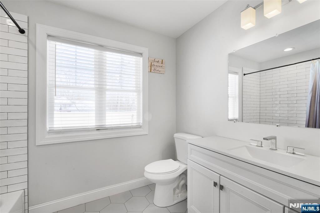 506 Brooklyn Mountain Road Hopatcong, NJ 07843 - Photo 17 of 30 a bathroom with a toilet a sink a vanity and a window