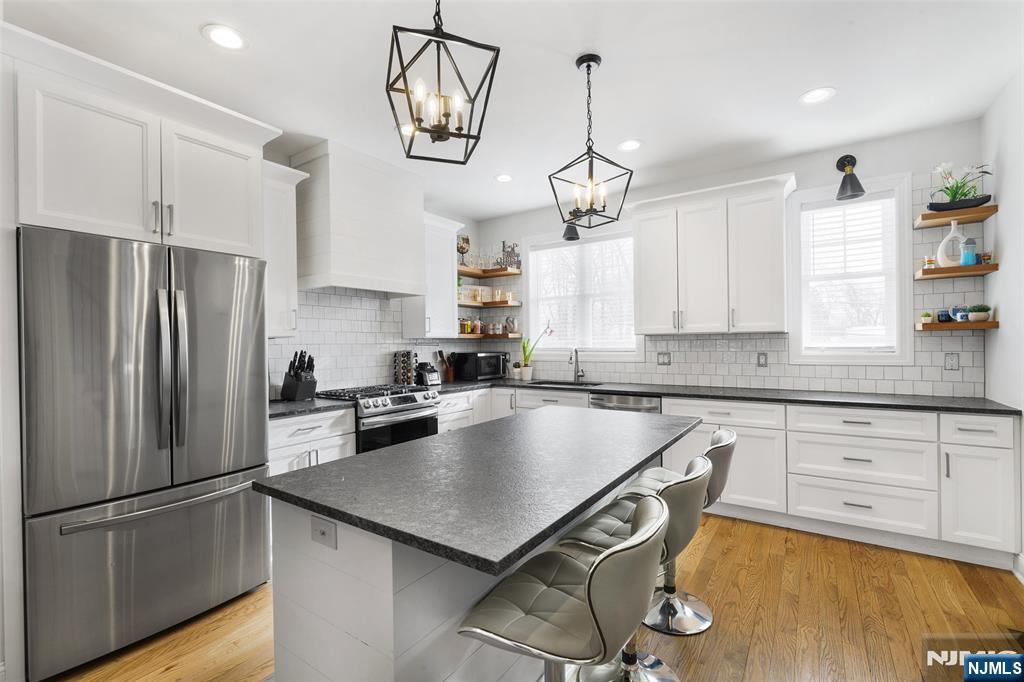 506 Brooklyn Mountain Road Hopatcong, NJ 07843 - Photo 7 of 30 a kitchen with kitchen island granite countertop stainless steel appliances a table chairs refrigerator and microwave