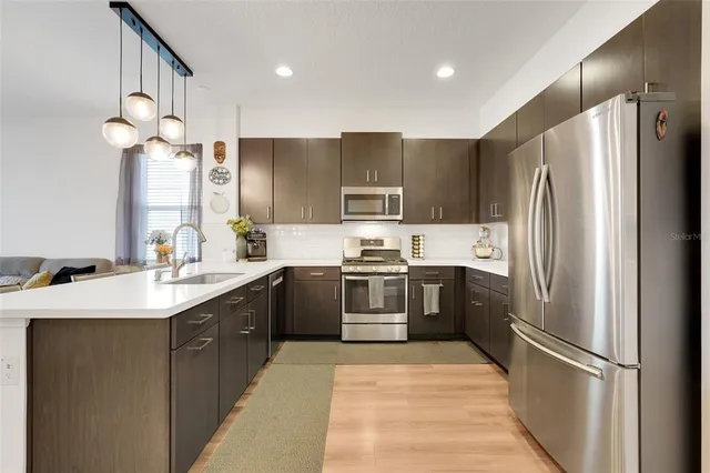a kitchen with a refrigerator a sink and cabinets