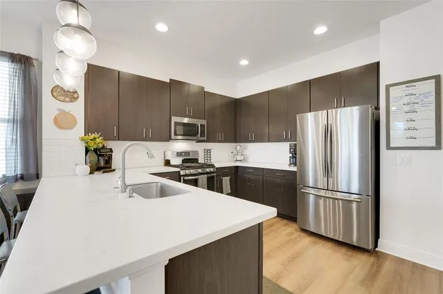 a kitchen with kitchen island a counter top space cabinets and stainless steel appliances