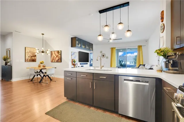 a open kitchen with a sink dishwasher and a stove with wooden floor