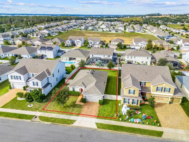 an aerial view of residential houses with outdoor space and parking