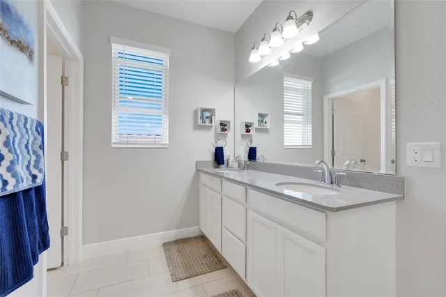 a bathroom with a granite countertop sink a large mirror and a window