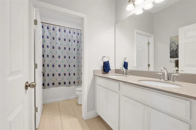 a bathroom with a double vanity sink toilet and shower