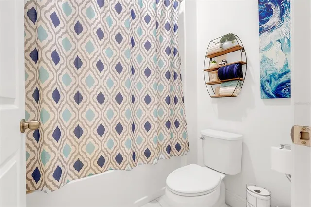 a white toilet sitting next to a shower curtain