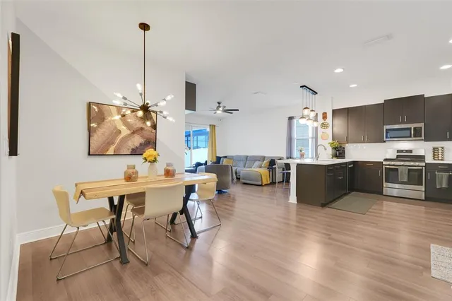 a living room with stainless steel appliances kitchen island granite countertop furniture wooden floor and a view of kitchen