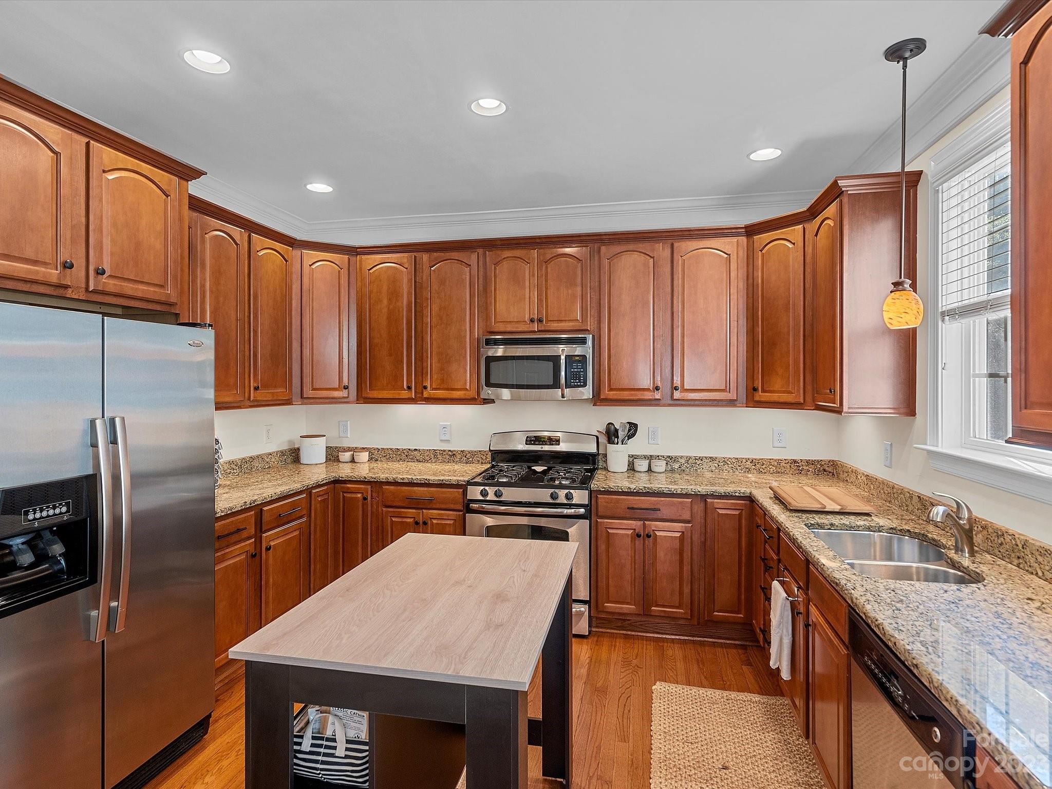 4136 Sunset Ridge Drive Rock Hill, SC 29732 - Photo 19 of 44 a kitchen with stainless steel appliances granite countertop a stove top oven a sink dishwasher a refrigerator and cabinets with wooden floor