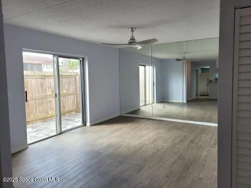 an empty room with chandelier fan and windows