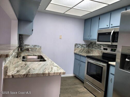 732 Ridge Club Drive, Unit 49 Melbourne, FL 32934 - Photo 9 of 20 a kitchen with granite countertop a sink stove and microwave