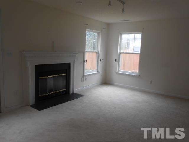4113 Hopper Street Raleigh, NC 27616 - Photo 6 of 15 an empty room with windows and fireplace