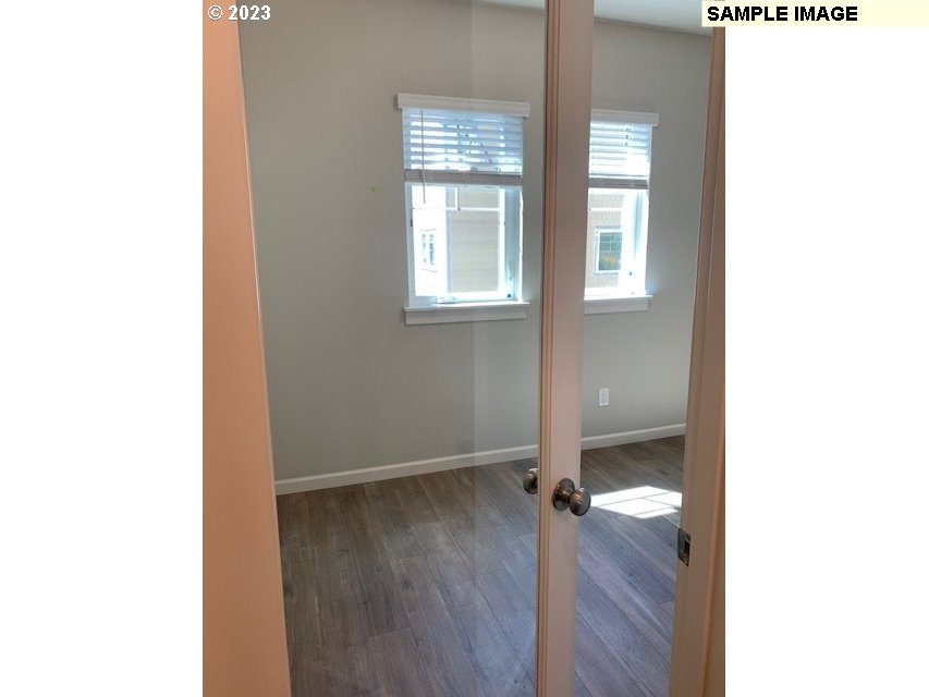 12011 Southeast High Creek Road, Unit C Happy Valley, OR 97086 - Photo 11 of 20 a view of an empty room with wooden floor and a window