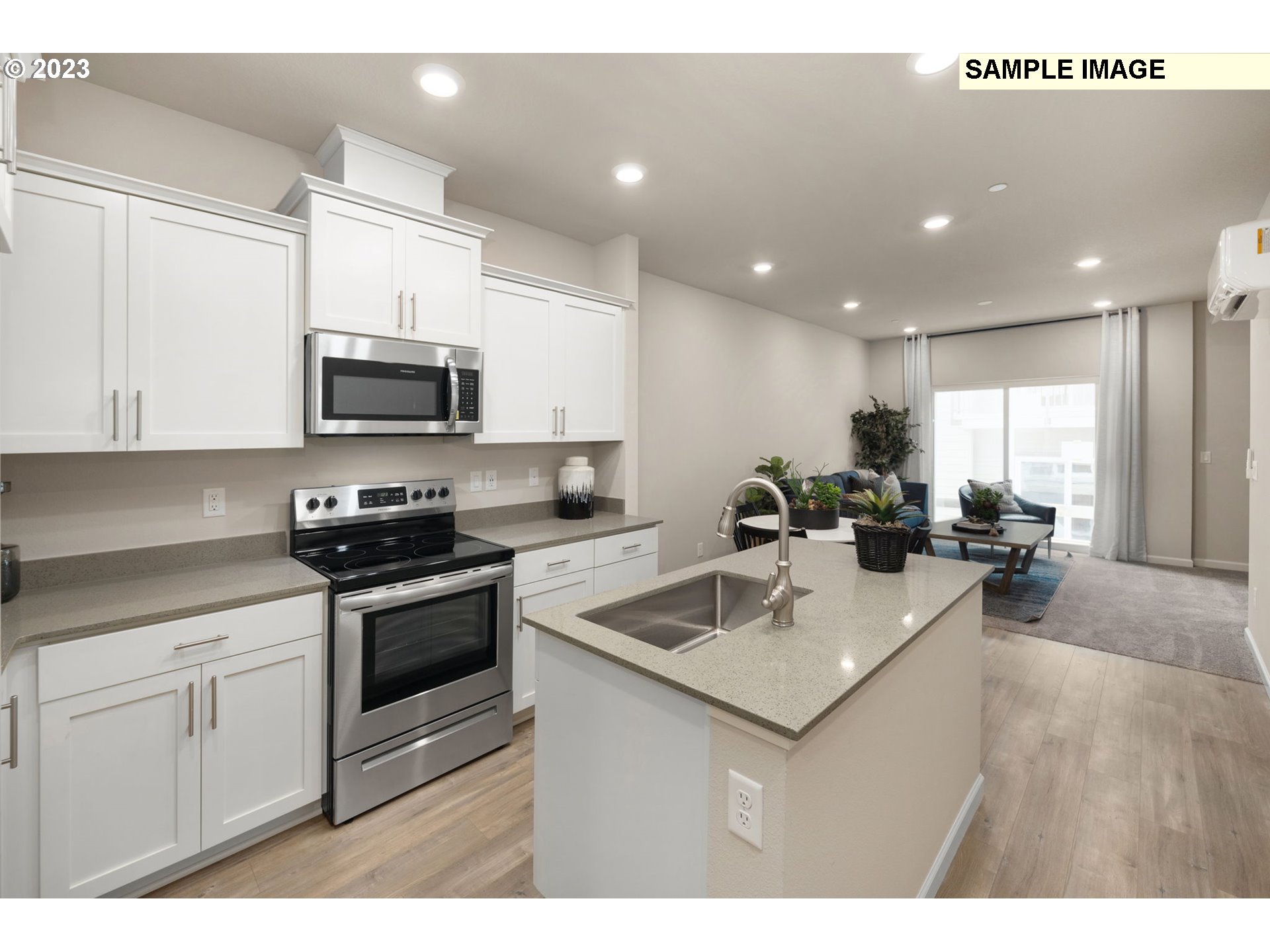 12011 Southeast High Creek Road, Unit C Happy Valley, OR 97086 - Photo 7 of 20 a kitchen with a sink a stove a microwave and cabinets