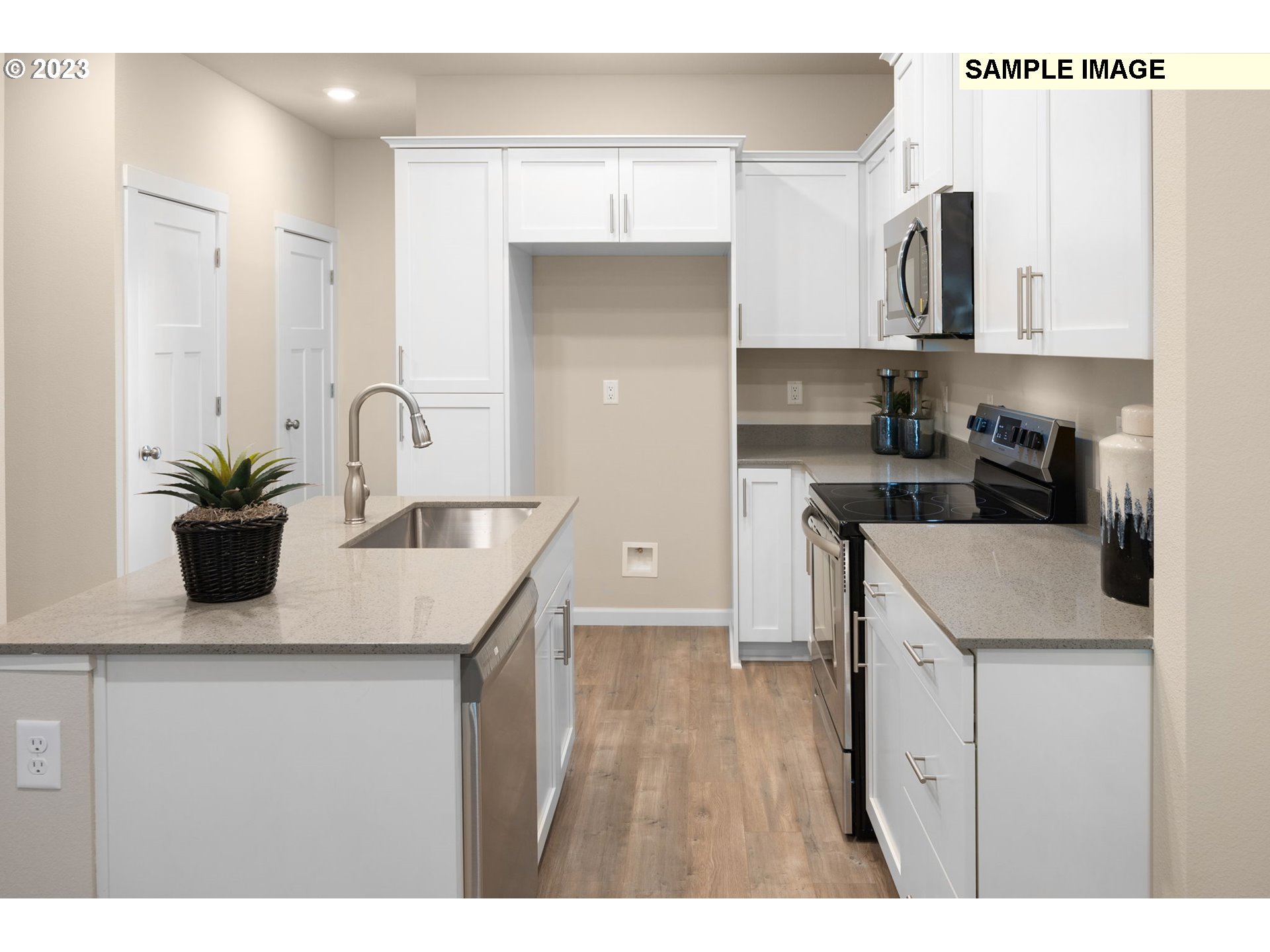12011 Southeast High Creek Road, Unit C Happy Valley, OR 97086 - Photo 8 of 20 a kitchen with a sink dishwasher and white cabinets with wooden floor
