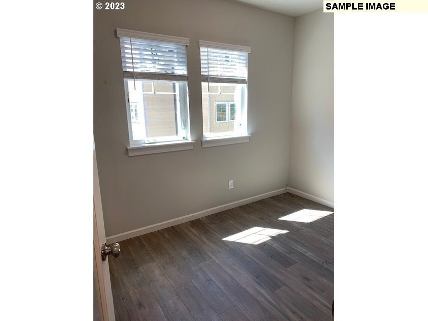 12011 Southeast High Creek Road, Unit C Happy Valley, OR 97086 - Photo 10 of 20 a view of an empty room with wooden floor and a window