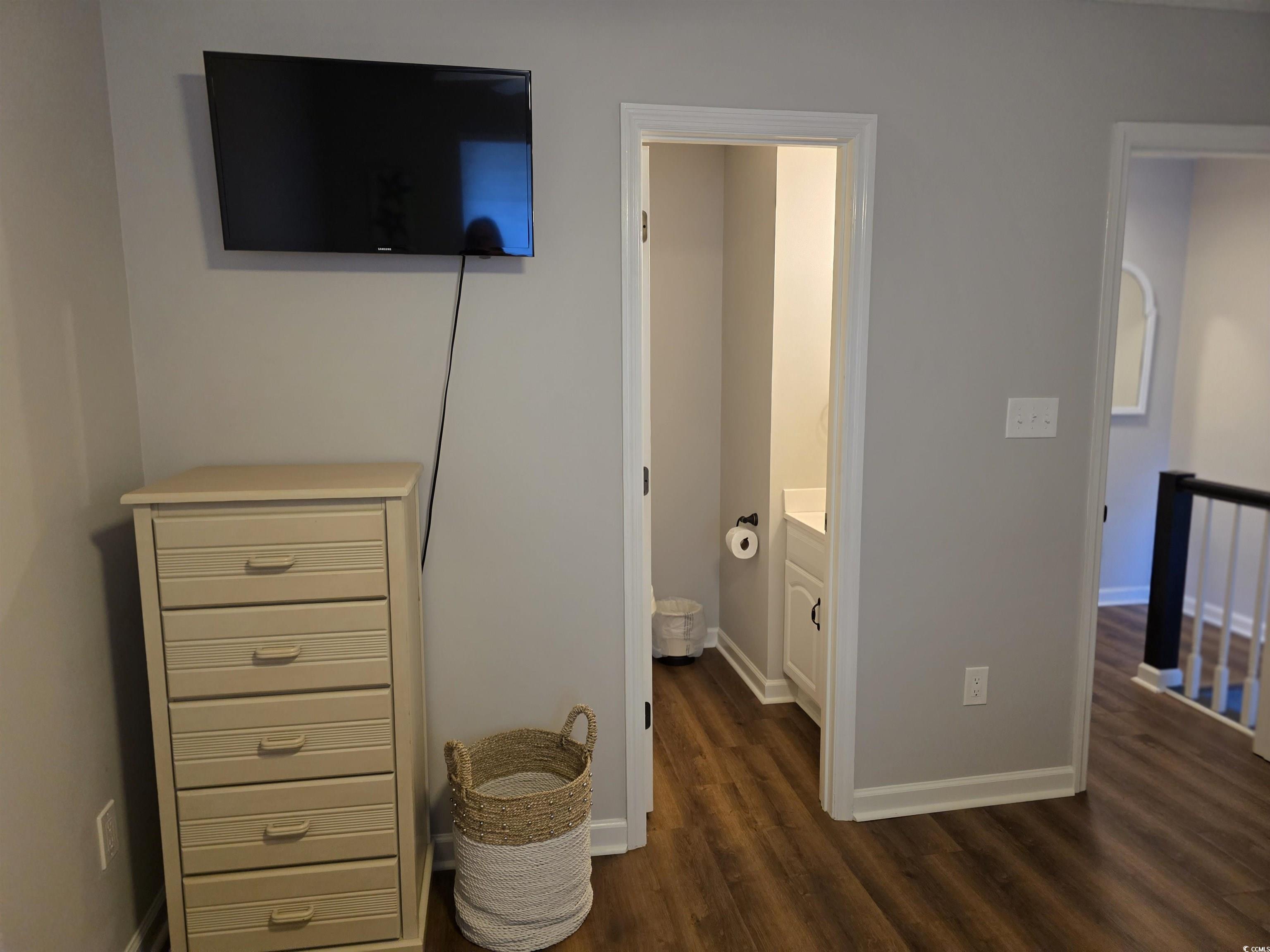 1637 Club Circle, Unit 18 Pawleys Island, SC 29585 - Photo 19 of 20 Bedroom featuring dark wood-style flooring and ensuite bath