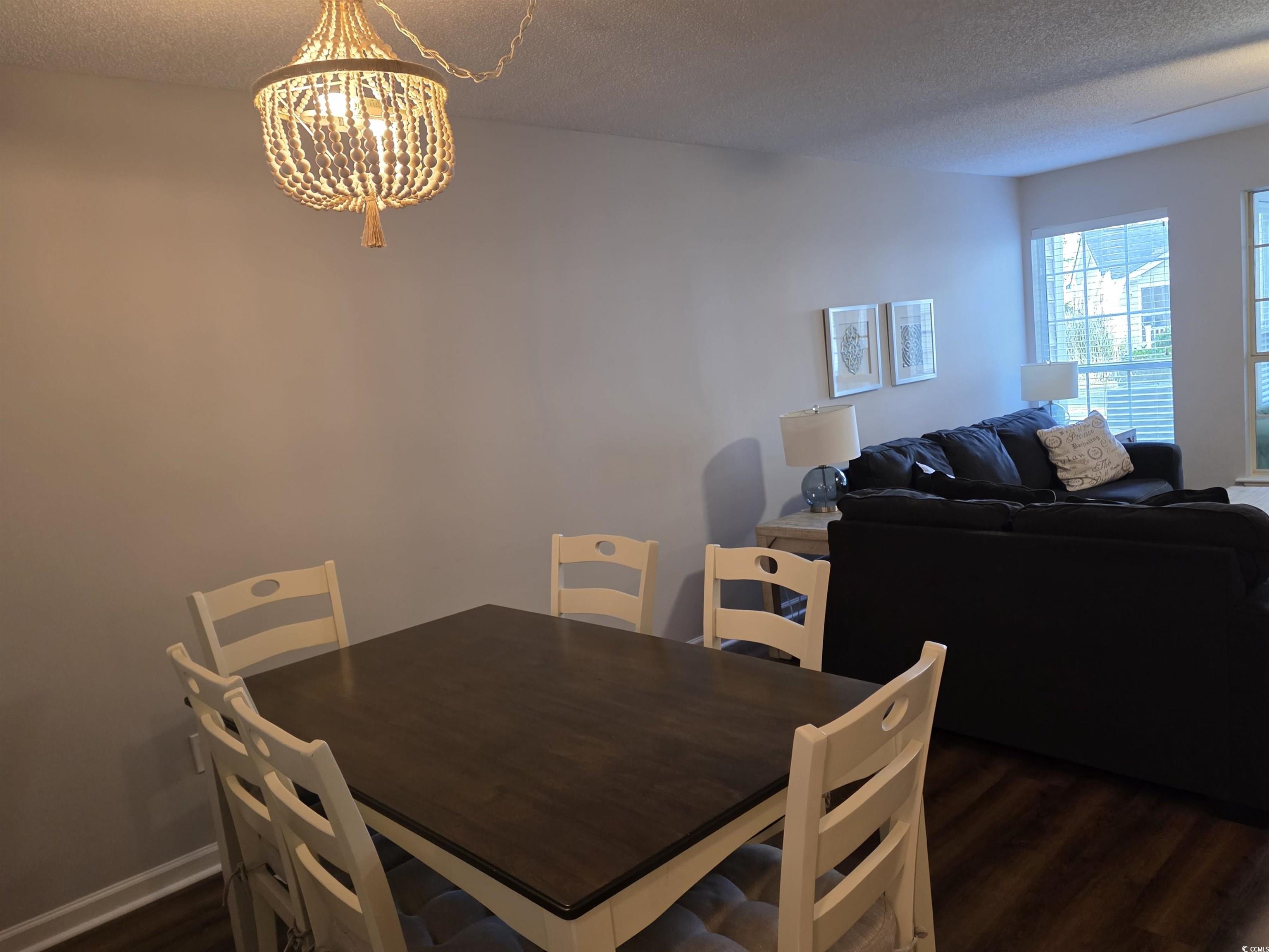1637 Club Circle, Unit 18 Pawleys Island, SC 29585 - Photo 5 of 20 Dining room featuring a textured ceiling, dark wood-style floors, and a chandelier