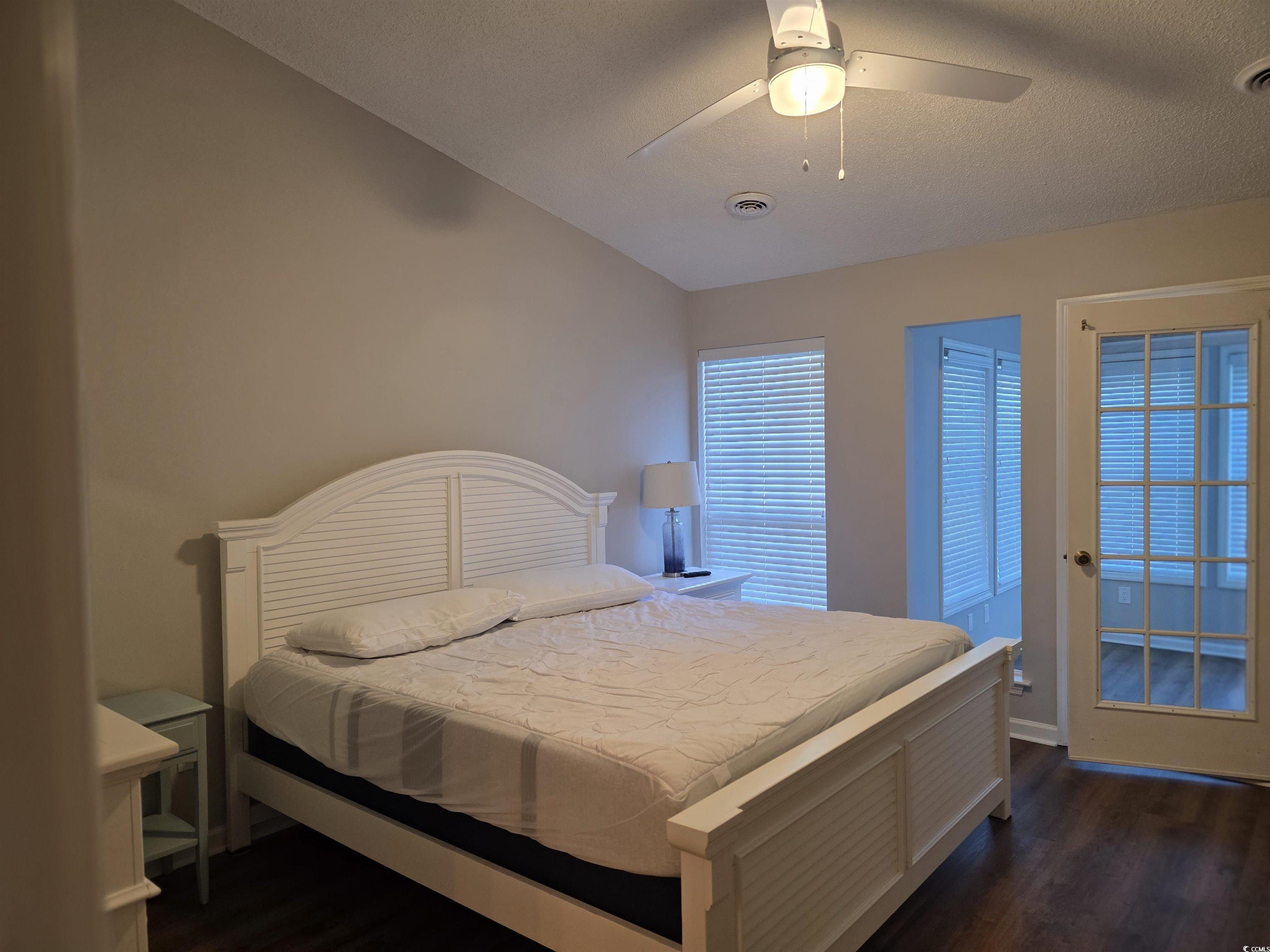 1637 Club Circle, Unit 18 Pawleys Island, SC 29585 - Photo 10 of 20 Bedroom featuring ceiling fan, dark wood-style floors, and a textured ceiling