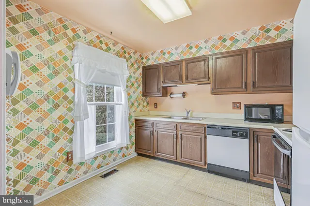 a kitchen with stainless steel appliances granite countertop a sink and cabinets