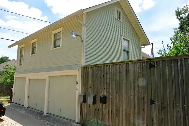 a back view of a house with wooden fence