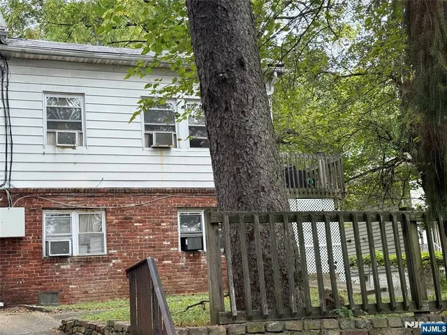 a front view of a house with a tree