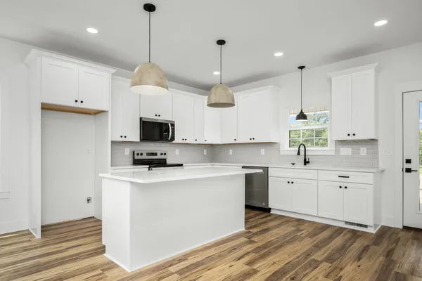 a kitchen with white cabinets and black appliances