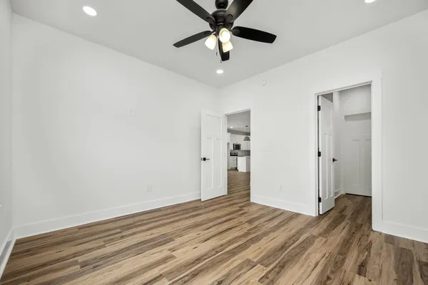 a view of a room with wooden floor and a ceiling fan