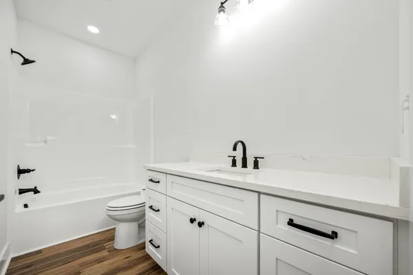 a spacious bathroom with a toilet sink a mirror and shower