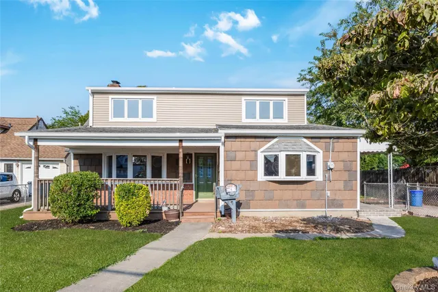 a front view of a house with a yard and outdoor seating