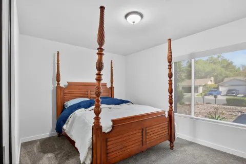 a bedroom with a bed and large window