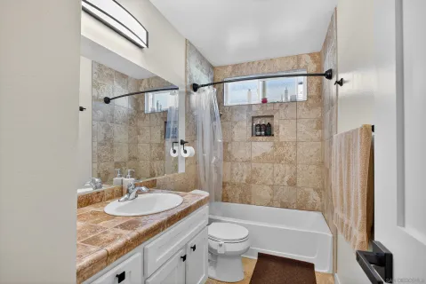 a bathroom with a granite countertop sink toilet and shower