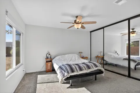 a bedroom with a bed a chandelier and a large window