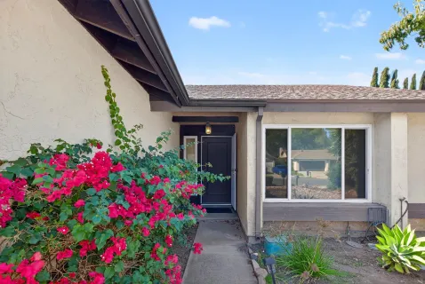 a front view of a house with a flower garden