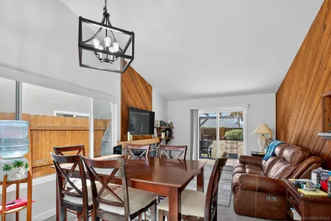 a dining room with furniture a flat screen tv and a window