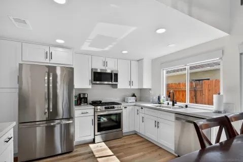a kitchen with stainless steel appliances a refrigerator sink and microwave