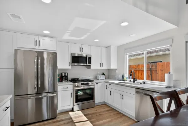 a kitchen with stainless steel appliances a refrigerator sink and microwave