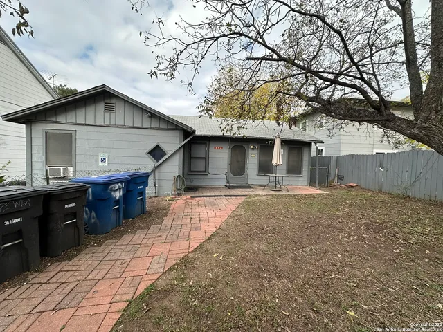 a view of house with backyard and trees
