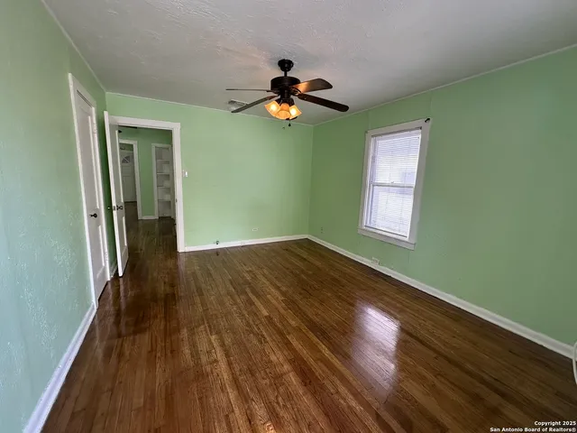 a view of empty room with wooden floor