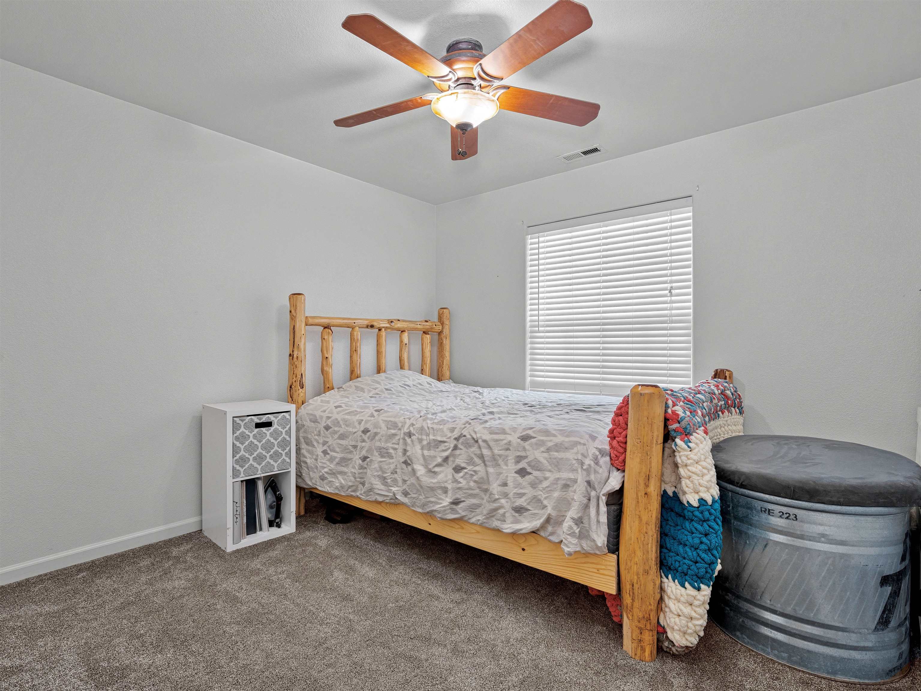 680 Stone Mountain Drive Fruita, CO 81521 - Photo 16 of 32 a bedroom with a bed and a chandelier