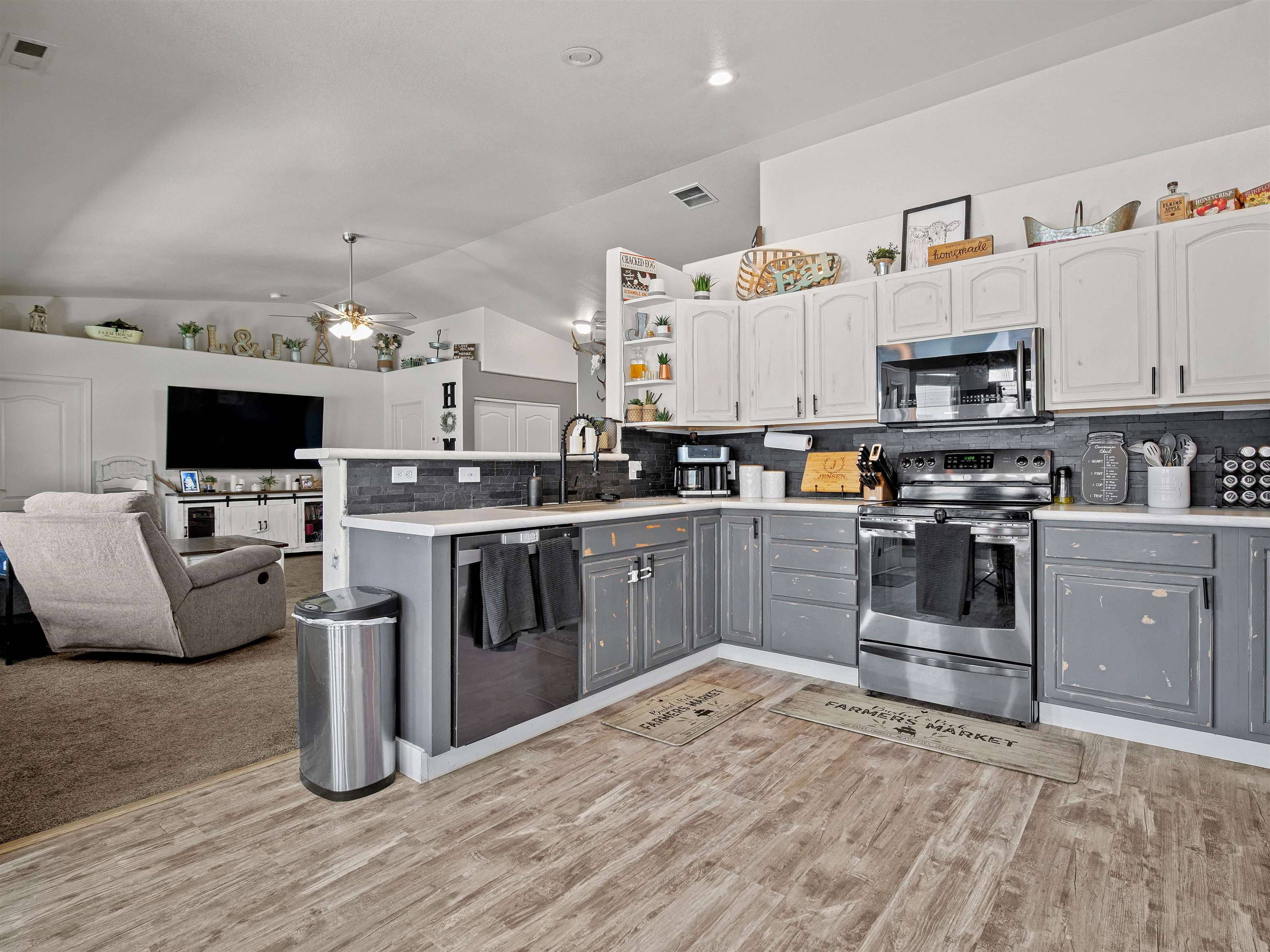 680 Stone Mountain Drive Fruita, CO 81521 - Photo 21 of 32 a kitchen with stainless steel appliances granite countertop a stove top oven a sink dishwasher and a refrigerator with wooden floor
