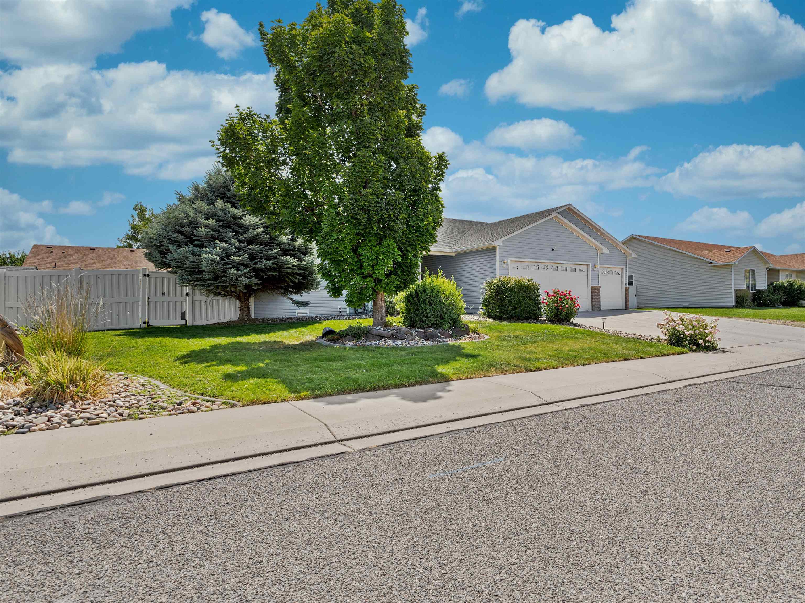 680 Stone Mountain Drive Fruita, CO 81521 - Photo 30 of 32 a view of a house with a yard and large tree and plants
