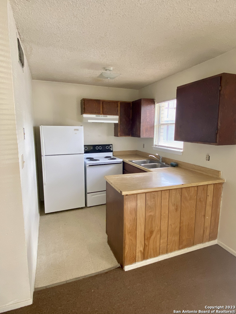 a kitchen with stainless steel appliances a refrigerator a stove a sink and a more cabinets