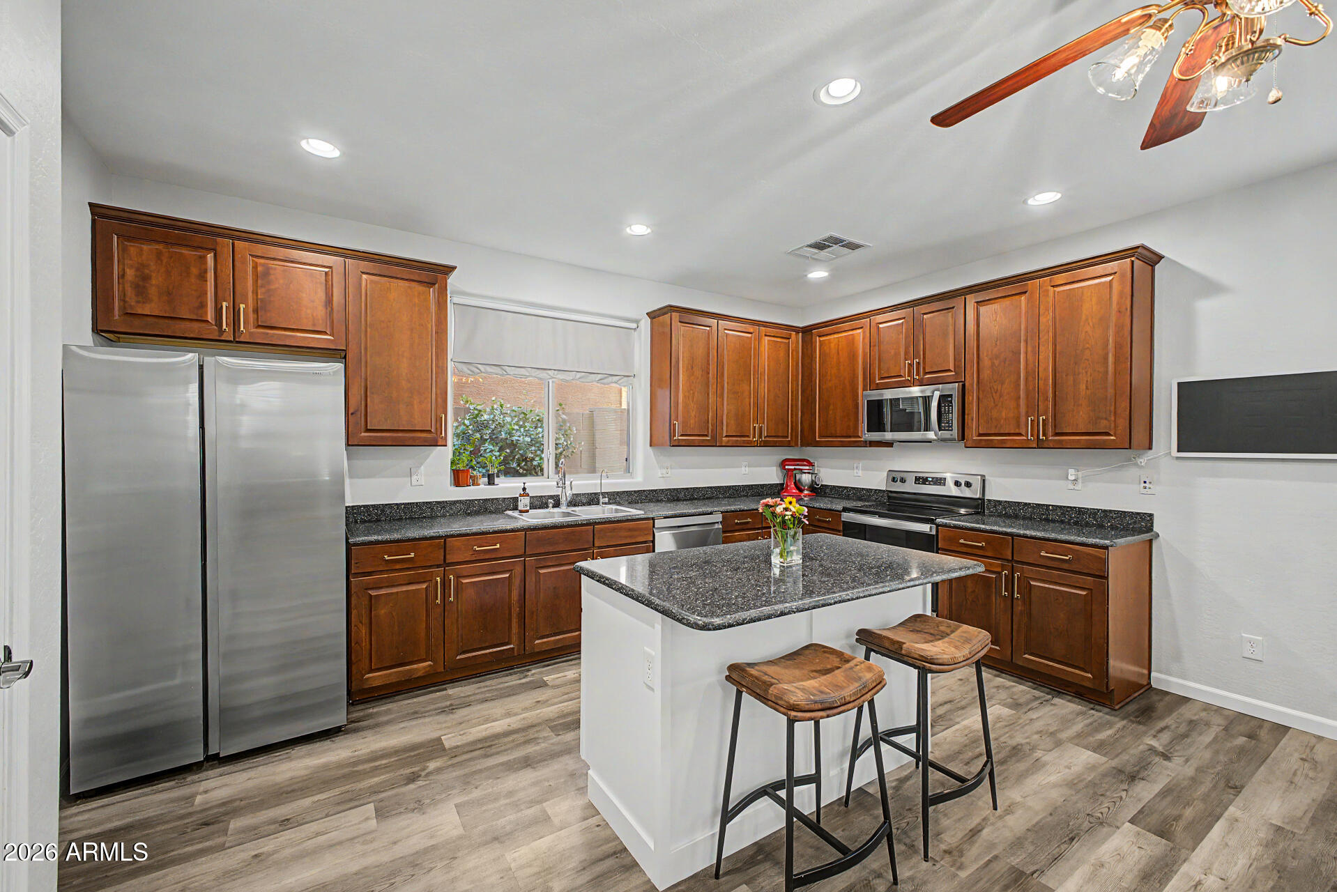 4331 East Cullumber Street Gilbert, AZ 85234 - Photo 11 of 42 a kitchen with stainless steel appliances granite countertop a refrigerator a sink dishwasher a stove and white countertops with wooden floor