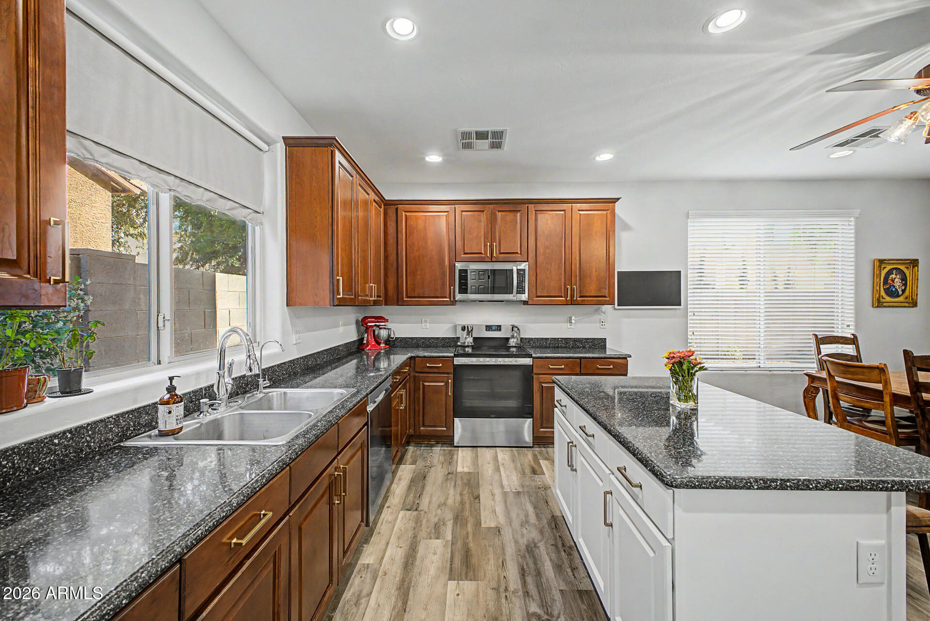 4331 East Cullumber Street Gilbert, AZ 85234 - Photo 12 of 42 a kitchen with granite countertop stainless steel appliances a sink a counter top space cabinets and a large window