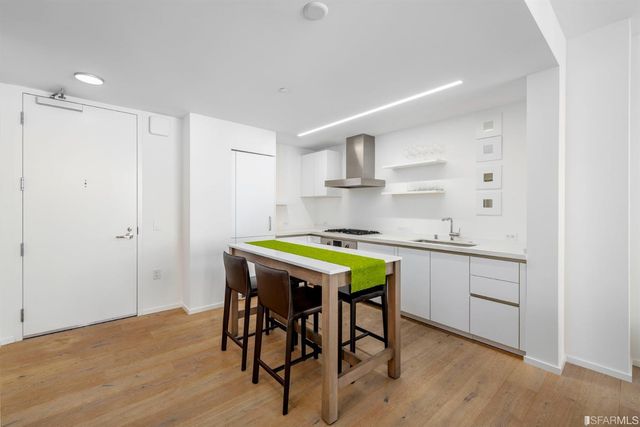 a kitchen with a table chairs sink and cabinets