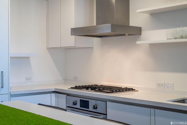 a kitchen with stainless steel appliances a dining table chairs and sink