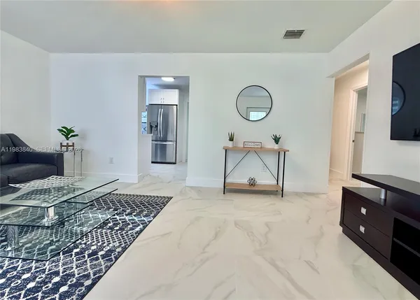 a living room with furniture a rug and a flat screen tv